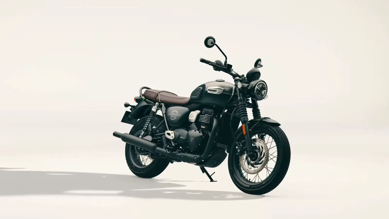 2027 Triumph Bonneville T40 Black in matt grey and black with a brown seat on a pale studio backdrop