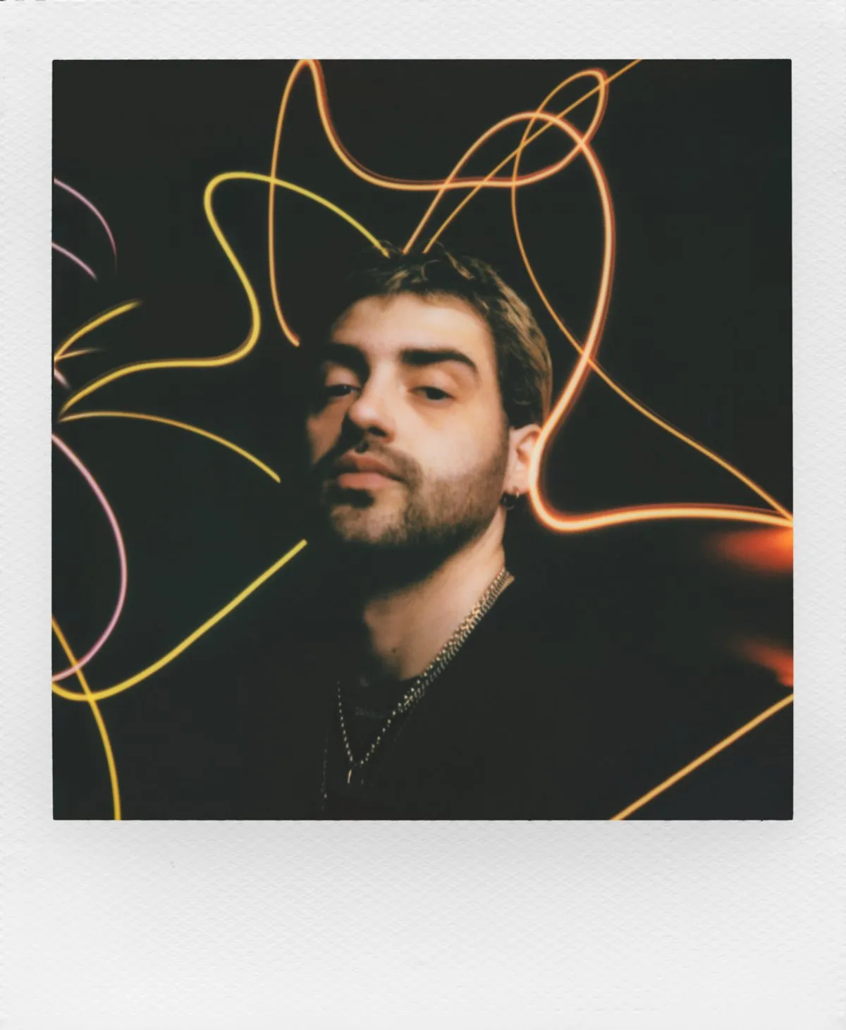 Instant print made with the Light Painting mode, showing glowing light trails around a portrait